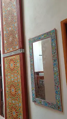 a mirror on a wall next to a door at chez dar Ayoub in Fès