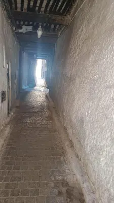 an empty alley way with a light at the end of a tunnel at chez dar Ayoub in Fès
