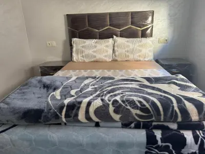 a bed with a black and white blanket on it at Darappart in Fès