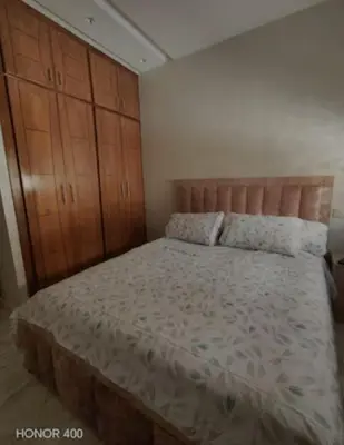 a bedroom with a large bed and wooden cabinets at Darappart in Fès