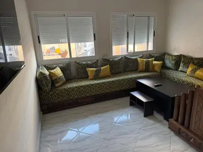 a couch in a living room with windows at Darappart in Fès