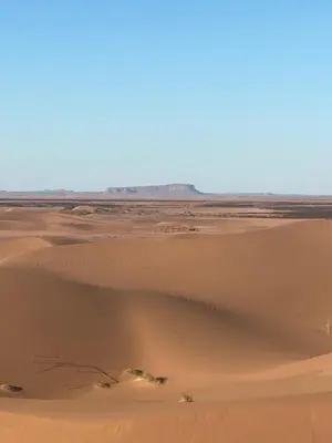 a view of the desert from the top of a sand dune at Desert Family Camp in El Gouera