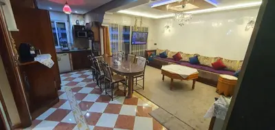 a living room with a table and a couch at Appartement tout confort sur la corniche à proximité plage in Oulad Akkou