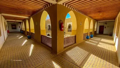 an empty hallway of a building with yellow walls at Riad Ksar Assalassil Erfoud in Erfoud