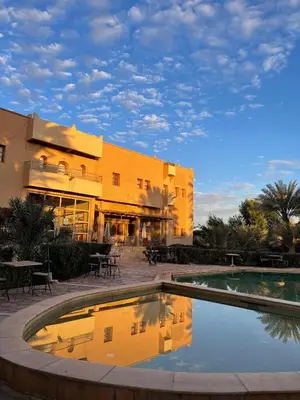a hotel with a pool in front of a building at Riad Ksar Assalassil Erfoud in Erfoud