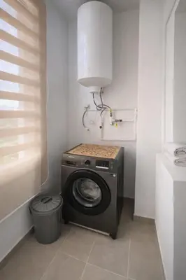 a washer and dryer in a corner of a room at Luxury Apartment Prestigia Champ Cours Garden View in Fès
