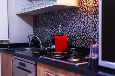 a kitchen with a stove with a red towel on it at Luxury Apartment Prestigia Champ Cours Garden View in Fès