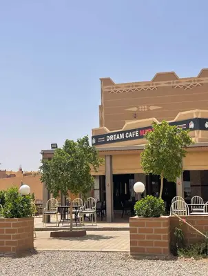 a building with chairs and tables in front of it at Dream Merzouga Rooms in Merzouga
