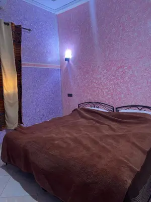 a bedroom with a bed with a purple wall at Dream Merzouga Rooms in Merzouga