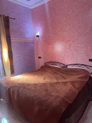 a bedroom with a bed in a room with purple walls at Dream Merzouga Rooms in Merzouga