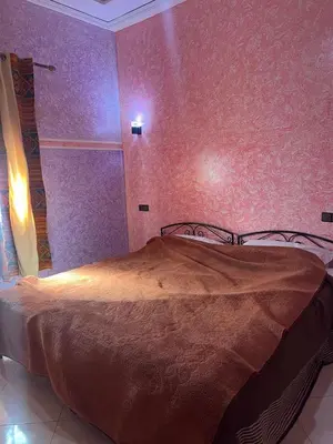 a bedroom with a bed in a room with purple walls at Dream Merzouga Rooms in Merzouga