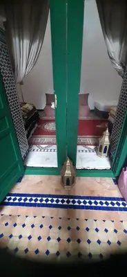 a stairway with a green door and a checkered floor at JARDIN hOSTEL in Fès