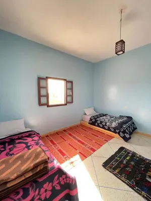 a room with two beds and a window at Sahara desert Maison in Merzouga