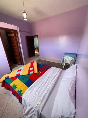 a bedroom with a colorful bed and a chair at Sahara desert Maison in Merzouga