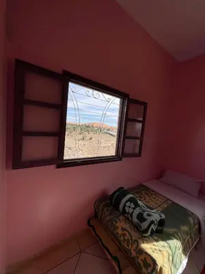 a bedroom with a bed and a window at Sahara desert Maison in Merzouga