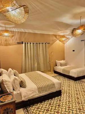 a bedroom with two beds in a room at riad tighmart in Merzouga