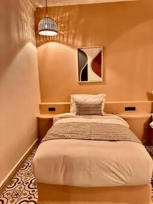 a bedroom with a bed and a pendant light at riad tighmart in Merzouga