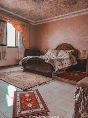 a bedroom with a bed and a rug on the floor at casa medina sanaa in Oulad Akkou