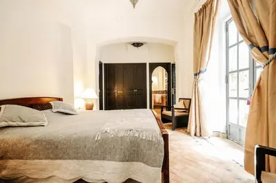 a bedroom with a bed and a large window at Villa l'Aziza in Najem
