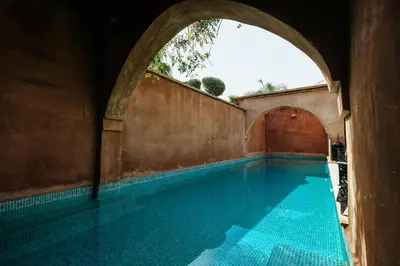 an empty swimming pool with an archway in a building at Villa l'Aziza in Najem