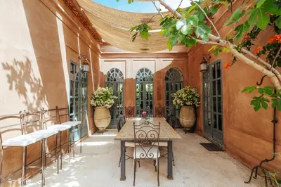 a patio with tables and chairs in a building at Villa l'Aziza in Najem