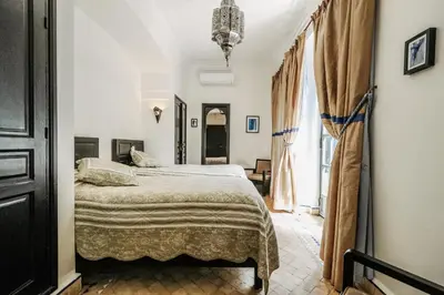 a bedroom with a bed and a large window at Villa l'Aziza in Najem