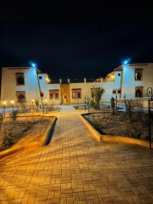 a cobblestone street in front of a building at night at riad tighmart in Merzouga