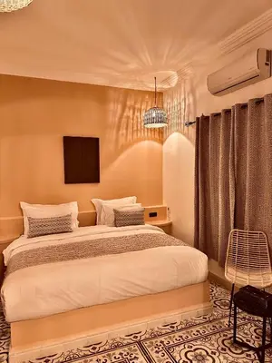 a bedroom with a bed and a tv on the wall at riad tighmart in Merzouga