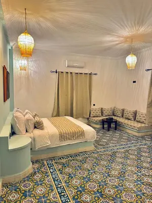 a bedroom with a bed and a couch in a room at riad tighmart in Merzouga