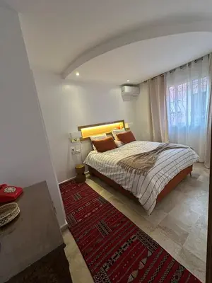 a bedroom with a bed and a red rug at Modern accommodation with Riad spirit in Hivernage in Oulad Akkou