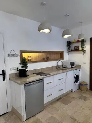 a kitchen with white cabinets and a sink and a dishwasher at Modern accommodation with Riad spirit in Hivernage in Oulad Akkou