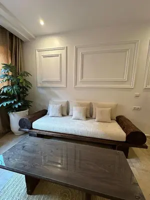 a bed in a room with a table at Modern accommodation with Riad spirit in Hivernage in Oulad Akkou