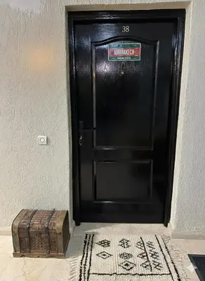 a black door with a suitcase in front of it at Modern accommodation with Riad spirit in Hivernage in Oulad Akkou