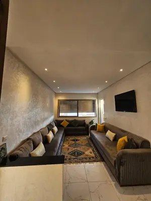a living room with a couch and a tv at CONFORT HOMe in Oulad Akkou