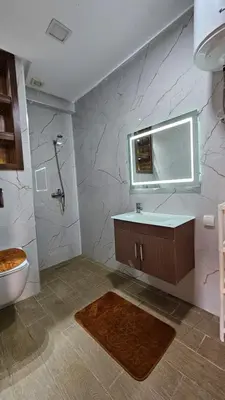 a bathroom with a sink and a toilet and a mirror at CONFORT HOMe in Oulad Akkou