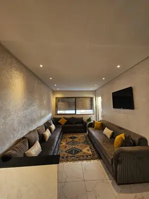 a living room with a couch and a tv at CONFORT HOMe in Oulad Akkou