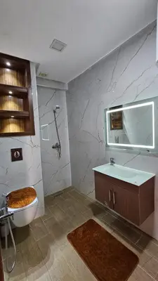 a bathroom with a toilet and a sink and a mirror at CONFORT HOMe in Oulad Akkou