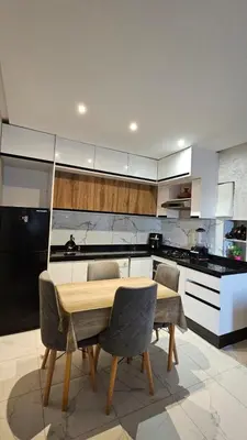 a kitchen with a wooden table and some chairs at CONFORT HOMe in Oulad Akkou
