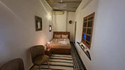 a bedroom with a bed and a table and chairs at Dar Boueden - lala hadhoum- Guest House in Fès