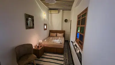 a small bedroom with a bed and a chair at Dar Boueden - lala hadhoum- Guest House in Fès