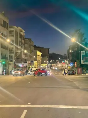 a city street at night with cars driving down the street at Studio haut-standing centre-ville parking-gratuit in Fès