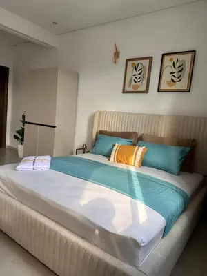a large bed with blue and orange pillows on it at Studio haut-standing centre-ville parking-gratuit in Fès