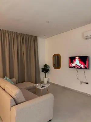 a living room with a couch and a tv at Studio haut-standing centre-ville parking-gratuit in Fès