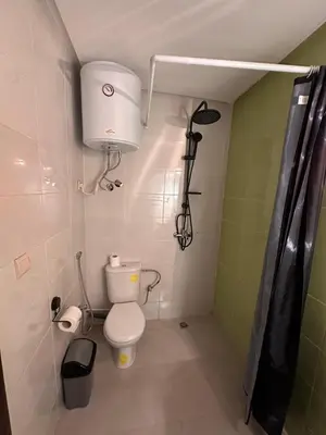 a small bathroom with a toilet and a shower at Studio haut-standing centre-ville parking-gratuit in Fès