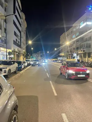 a car driving down a city street at night at Studio haut-standing centre-ville parking-gratuit in Fès