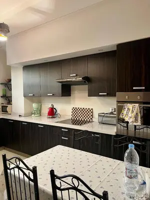 a kitchen with a table and chairs and a counter top at Moderne et spacieux appartement avec une belle vue - Espace Rihab centre ville in Fès