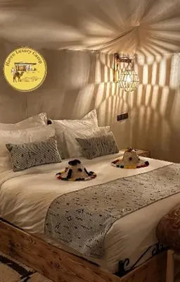 a bedroom with a bed with two stuffed animals on it at Haven Luxury Camp in Merzouga