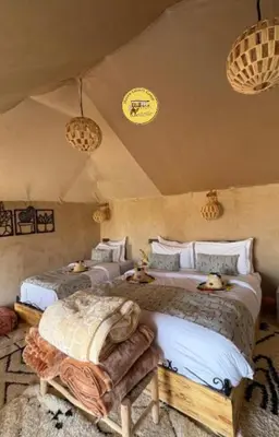a bedroom with two beds with stuffed animals on them at Haven Luxury Camp in Merzouga