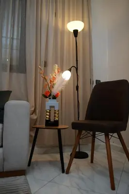 a living room with a chair and a lamp and a table at Stylish & Cozy Apartment with Modern Design in Beni Mellal