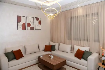 a living room with a white couch and a chandelier at Stylish & Cozy Apartment with Modern Design in Beni Mellal